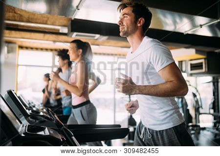 Happy Gorup Of Healthy People Training In Gym