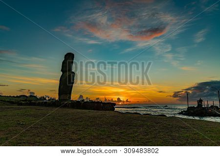Silhouette Of Single Moai At Fisherman Port In The Village Of Hanga Roa On Rapa Nui Island At Sunset