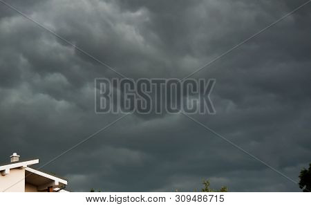 Gathering Dramatic Storm Clouds Over Residentual House During Summer, Conceptual Image Of Extreme We