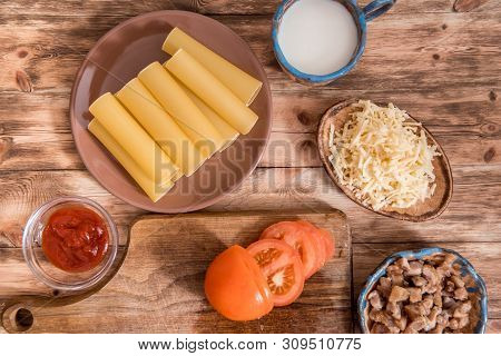Italian Food Concept. Ingredients For Cooking Pasta. Dry Cannelloni Pasta, Cherry Tomatoes, Fresh Ba