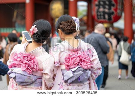 Young Girl Wearing Japanese Kimono Standing In Front Of Sensoji Temple In Tokyo, Japan. Kimono Is A