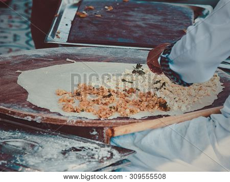 Turkish Woman Prepares Gozleme - Traditional Dish In The Form Of Flatbread Stuffed With Greens And C