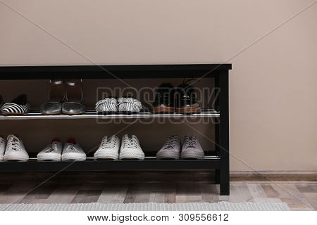Shoe Rack With Different Footwear Near Color Wall. Stylish Hallway Interior