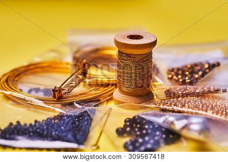 Embroidery Products And Tools. Coil Of Metal Thread, Japanese Beads And Sequins With Pin And Needles
