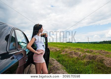 The Girl Near The Car Admires Nature. A Woman Near The Car Admires Nature