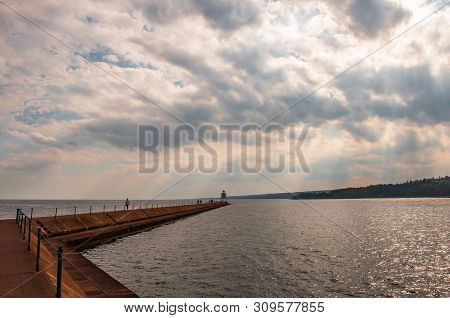 Two Harbors Breakwall And Navigation Light In Agate Bay Of Lake Superior With Dramatic Light Through