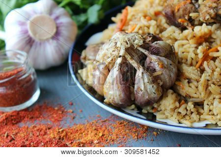Pilaf On A Platter Of Meat And Spices.pilaf In A Plate On A Wooden Background, Top View. The Concept