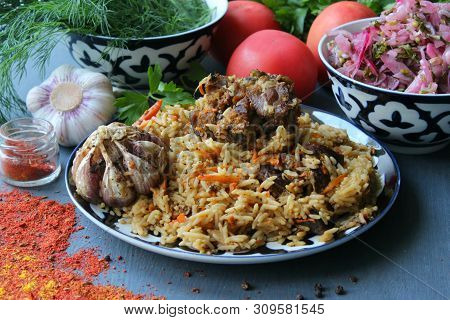 Pilaf On A Platter Of Meat And Spices.pilaf In A Plate On A Wooden Background, Top View.  The Concep