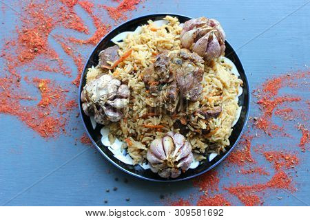 Pilaf On A Platter Of Meat And Spices.pilaf In A Plate On A Wooden Background, Top View.  The Concep