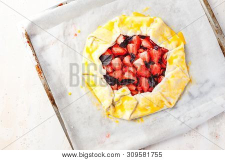 Homemade Strawberry Open Cake Of Gallet With Purple Basil And Balsamic Sauce Before Baking On A Ligh