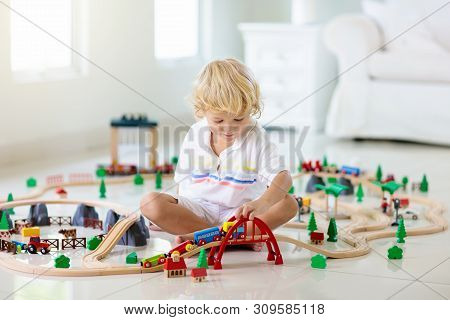Kids Play Wooden Railway. Child With Toy Train.