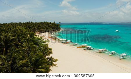 Sandy Beach With Tourists, Palm Trees And Turquoise Water On The Island Of Daco, Philippines, Aerial
