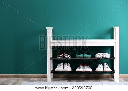 Shoe Rack With Different Footwear Near Color Wall, Space For Text. Stylish Hallway Interior