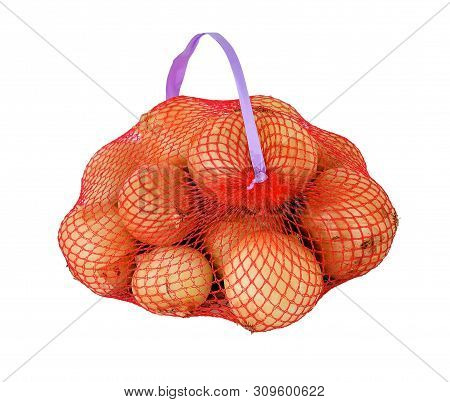 A Lot Of Yellow Onion In A Red Mesh Packaging With A Handle. Prepacked Vegetables In Store Mesh Pack