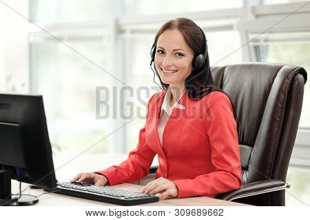 A Young Attractive Woman In A Red Jacket Sitting On A Desk At The Head Of A Executive In A Red Jacke