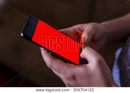 Man Hand Holding Mobile Phone In Coffee Shop. Man Using Smartphone. Empty Screen With Copy Space For