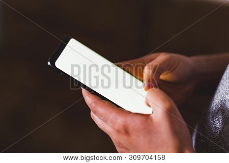 Man Hand Holding Mobile Phone In Coffee Shop. Man Using Smartphone. Empty Screen With Copy Space For