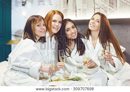 Young Women In White Bathrobe With Champagne Glasses At A Spa Party
