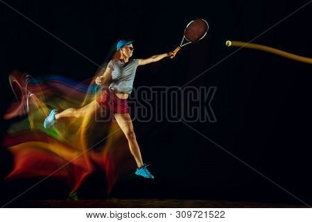 One Caucasian Woman Playing Tennis Isolated On Black Background In Mixed And Stobe Light. Fit Young 