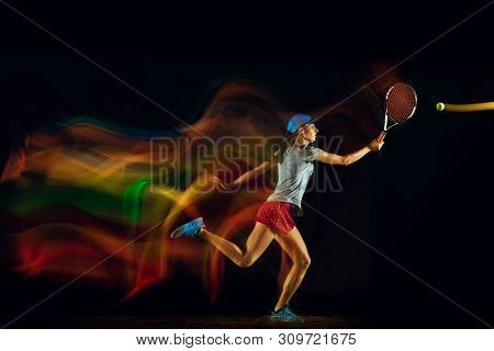 One Caucasian Woman Playing Tennis Isolated On Black Background In Mixed And Stobe Light. Fit Young 