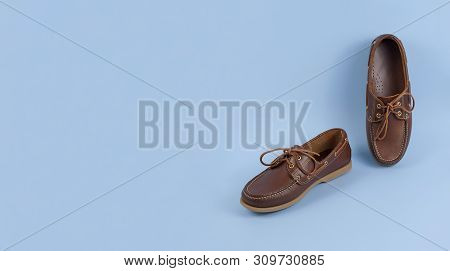 Brown Mens Topsiders Shoes On Blue Background With Reflection. Fashion Advertising Shoes. Copy Space