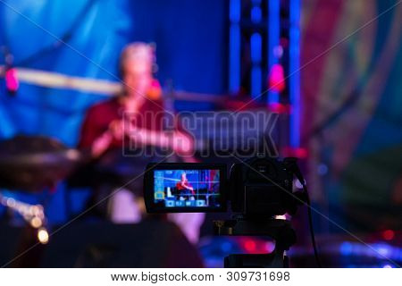 Video Camera Recording Ethnic Open Air Concert. Man With Tank Drum Or Hang On Blurry Abstract Bokeh 