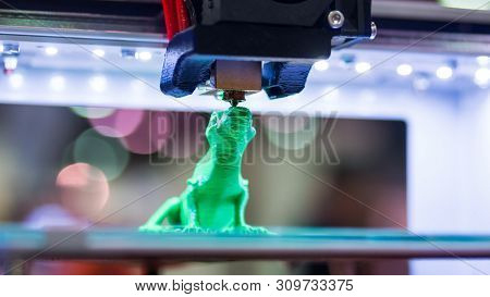 Print Head Of 3d Printer Machine Printing Plastic Model Of Green Toy Lizard At Modern Scifi Technolo