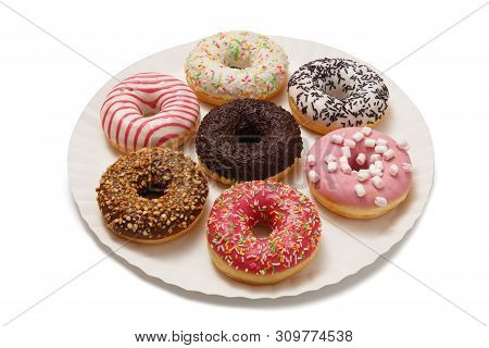 Sweet Doghnuts In Glaze Decorated With Sprinkles On A Paper Plate Isolated On A White Background