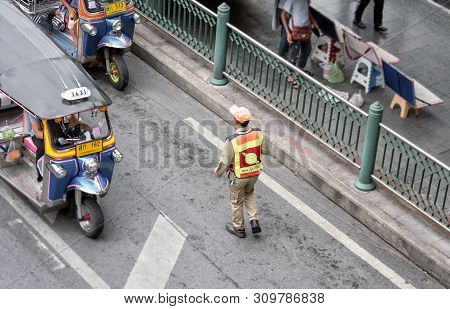 Bangkok, Thailand - June 29: Unnamed Traffic Warder Clears Illegally Parked Tuktuk Taxi In Bangkok O