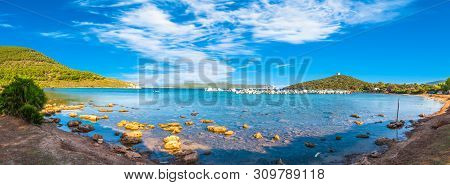 View Of Gulf, Pier And Beach Of Tramariglio In A Sunny And Cloudy Day, In The Capocaccia Coast