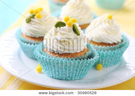Lindos cupcakes com decoração de creme e açúcar.