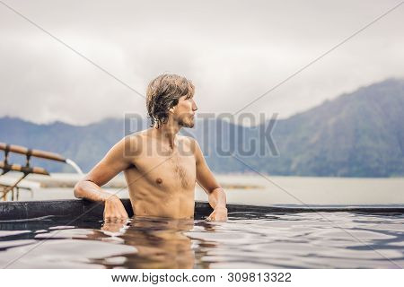 Geothermal Spa. Man Relaxing In Hot Spring Pool. Young Man Enjoying Bathing Relaxed In A Blue Water 