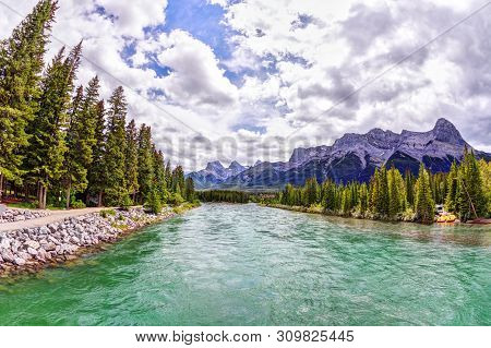 Bow River In Canmore With The Canadian Rockies Mountain Ranges Of The Three Sisters, Ehagay Nakoda A
