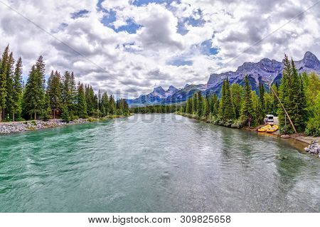 Bow River In Canmore With The Canadian Rockies Mountain Ranges Of The Three Sisters, Ehagay Nakoda A