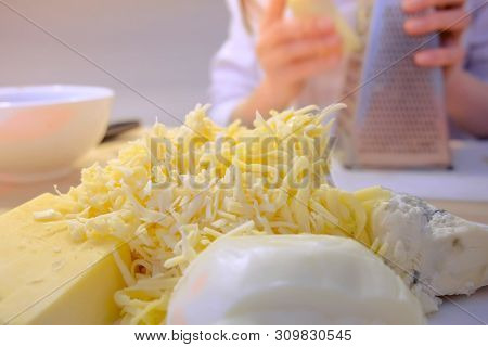 Woman Rubs Cheese On Grater At Home In The Kitchen, Hands Close-up