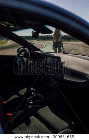 Girl On The Race Track. Holding Helmet