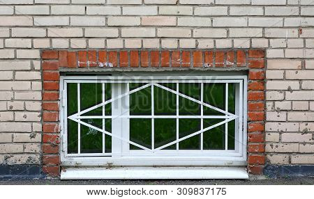 The Basement Window With A Metal Barrier