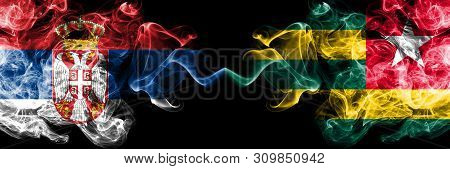 Serbia Vs Togo, Togolese Smoky Mystic Flags Placed Side By Side. Thick Colored Silky Smokes Combinat