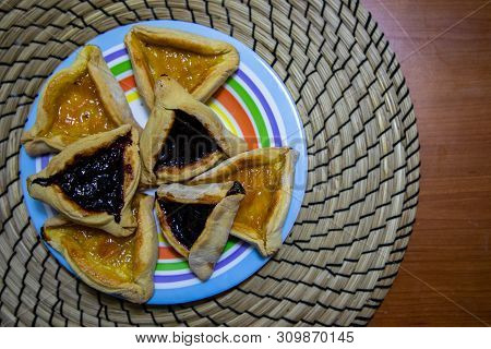 Hamantash Purim Blueberry And Apricot Jam Cookies In Colored Plate With Wooden Table Background