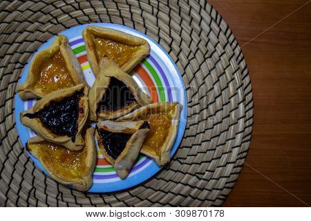 Hamantash Purim Blueberry And Apricot Jam Cookies In Colored Plate With Wooden Table Background