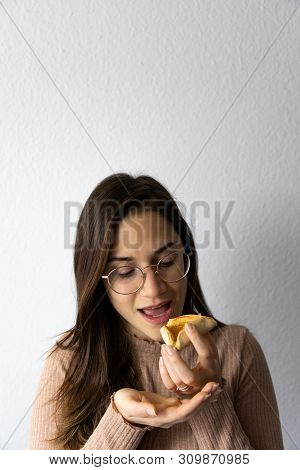 Beautiful And Happy Women Portrait Eating Hamantash Purim Apricot Cookie