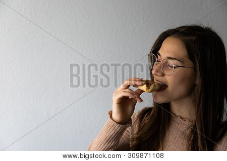 Beautiful And Happy Women Portrait Eating Hamantash Purim Apricot Cookie