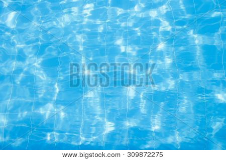 Water Vibrations In The Swimming Pool With Sun Reflection. Blue Swimming Pool Surface, Water Backgro