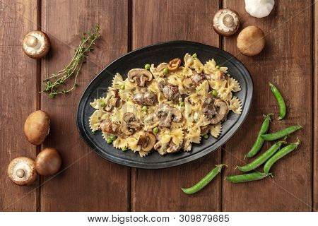Mushroom And Cheese Pasta. Farfalle With Cremini And Green Peas, Shot From The Top With Ingredients 
