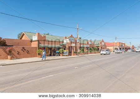 Warden, South Africa - May 1, 2019: A Street Scene With A Lodge, Restaurant, People And Vehicles, In