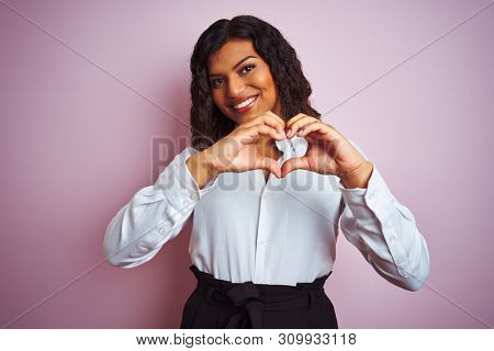 Beautiful transsexual transgender elegant businesswoman over isolated pink background smiling in love showing heart symbol and shape with hands. Romantic concept.