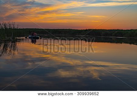 Picturesque Summer Sunset Over The Lake. Pink And Gold Clouds Are Reflected In The Water Surface. Uk