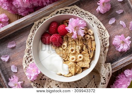 Breakfast Cereals With Yogurt And Raspberries, With Pink Kwanzan Cherry Blossoms