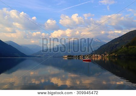 Reflections Of Clouds On The Water Surface Of A Mountain Lake Against The Backdrop Of The Taur Alps