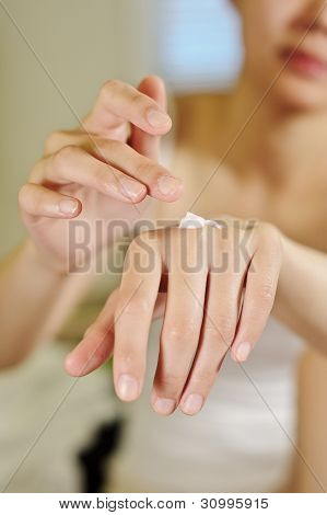 그녀의 손에 크림을 적용 하는 여성